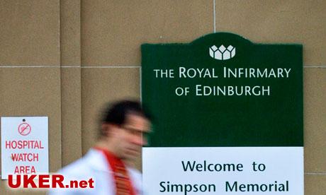 Doctor walks past Royal Infirmary of Edinburgh sign